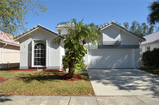 ranch-style home with a front yard, driveway, an attached garage, stucco siding, and a tiled roof