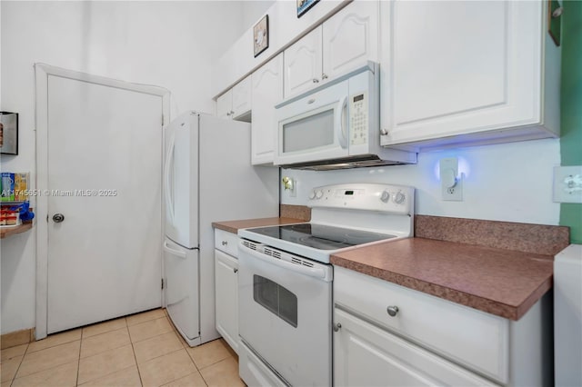 kitchen with white appliances, light tile patterned floors, and white cabinets