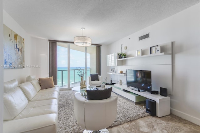 living room featuring a wall of windows and a textured ceiling