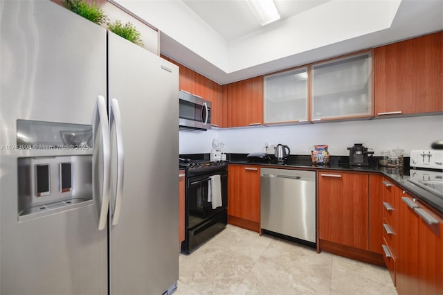 kitchen with sink, dark stone countertops, and stainless steel appliances