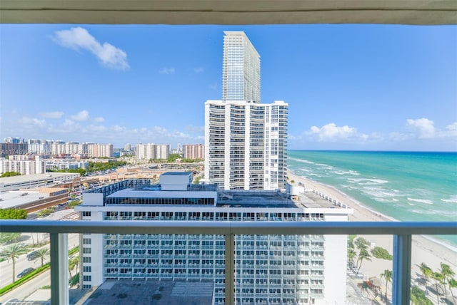 balcony with a water view and a view of the beach