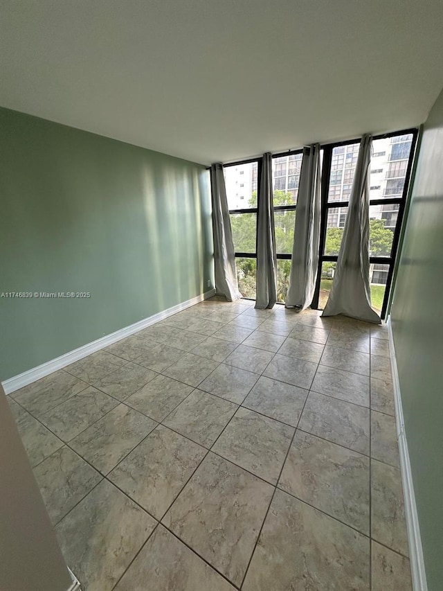 17011 N Bay Rd Unit 507, Sunny Isles Beach, FL 33160 - spare room featuring baseboards and expansive windows