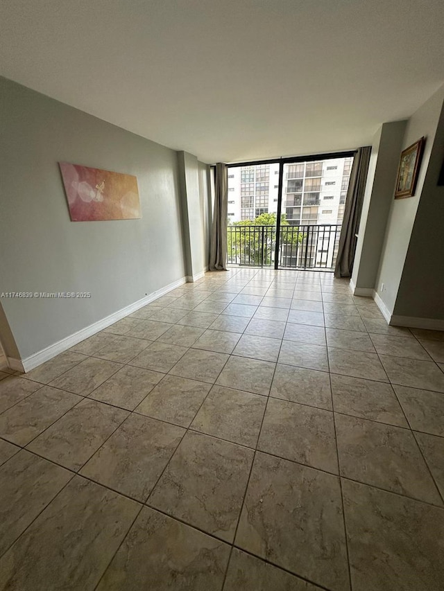 17011 N Bay Rd Unit 507, Sunny Isles Beach, FL 33160 - tiled spare room featuring a wall of windows and baseboards