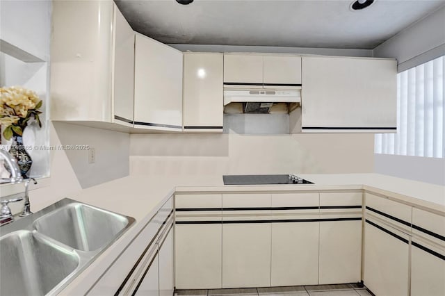 kitchen featuring white cabinetry, black electric cooktop, and sink