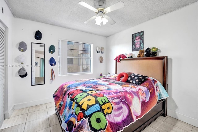 bedroom with light tile patterned flooring, ceiling fan, and a textured ceiling