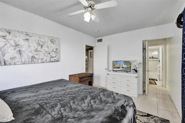 bedroom with ceiling fan, light tile patterned floors, and a textured ceiling