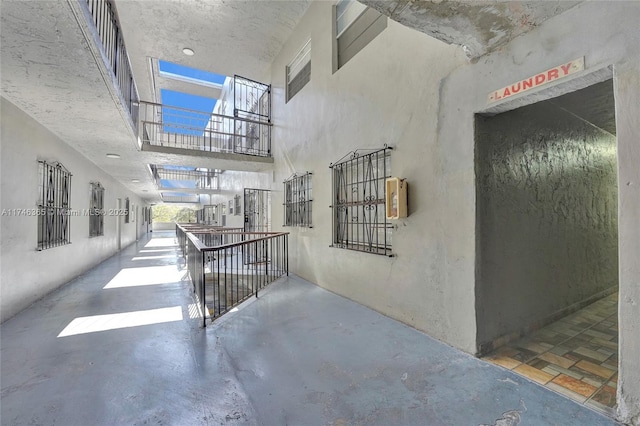 hall with concrete flooring and a towering ceiling