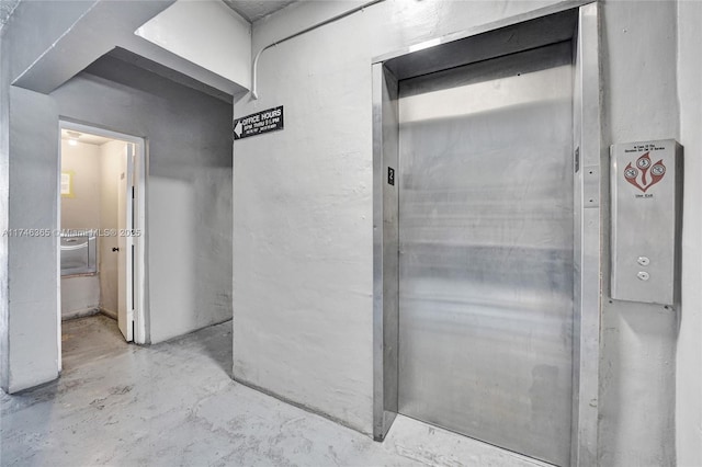 interior space with elevator and concrete flooring