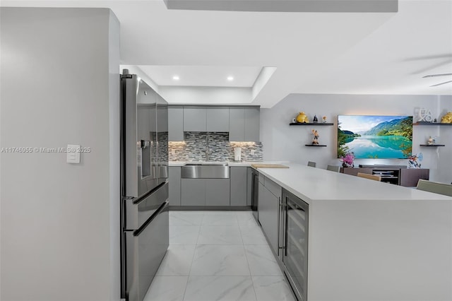 kitchen featuring wine cooler, sink, stainless steel refrigerator with ice dispenser, and gray cabinetry