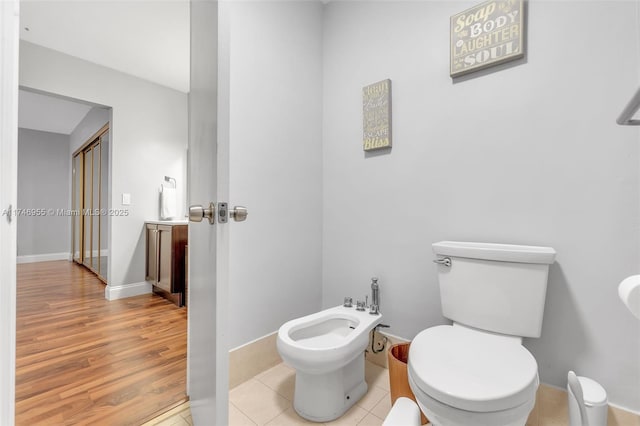 bathroom with a bidet, tile patterned flooring, and toilet