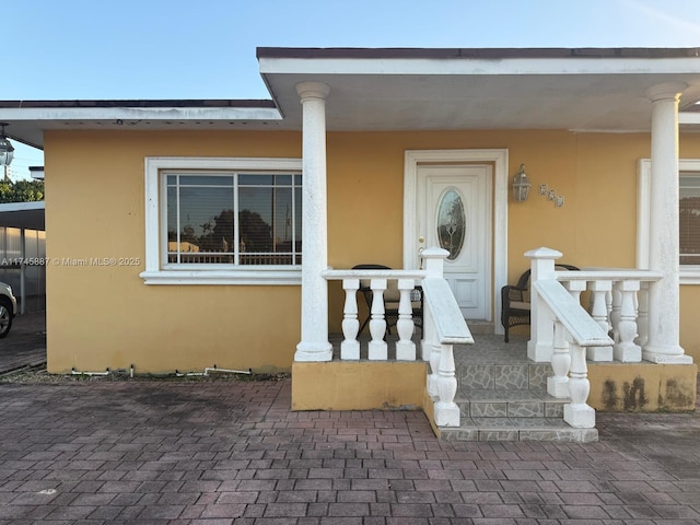 view of exterior entry with covered porch