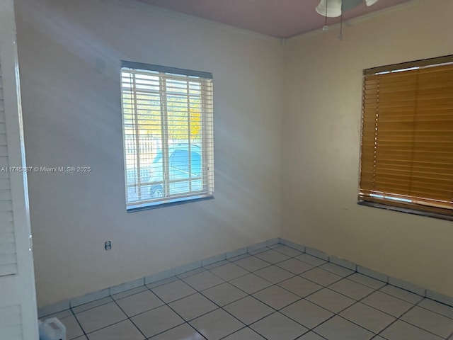 spare room featuring light tile patterned floors and crown molding