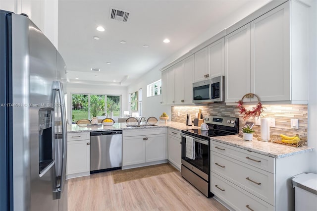 11539 SW Visconti Way, Port St Lucie, FL 34986 - kitchen with stainless steel appliances, recessed lighting, light wood-type flooring, light stone counters, and tasteful backsplash
