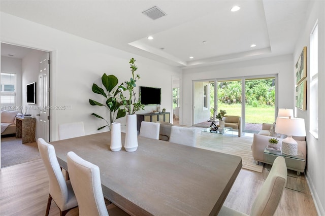 11539 SW Visconti Way, Port St Lucie, FL 34986 - dining space featuring light wood-type flooring, a tray ceiling, recessed lighting, and baseboards