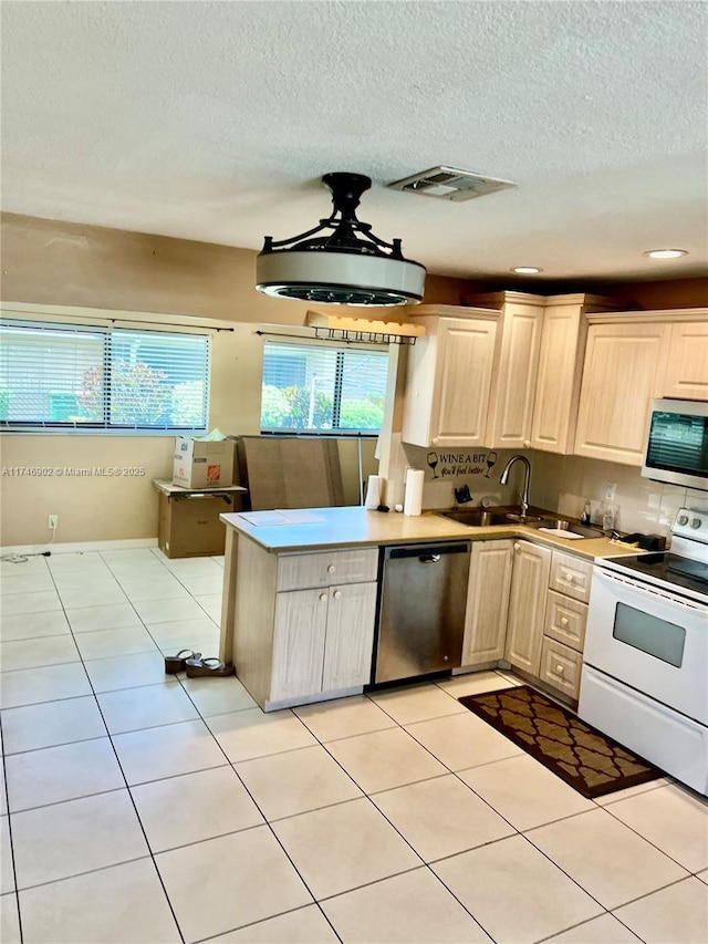 2713 NW 53rd St, Tamarac, FL 33309 - kitchen with light countertops, visible vents, a sink, a textured ceiling, and appliances with stainless steel finishes