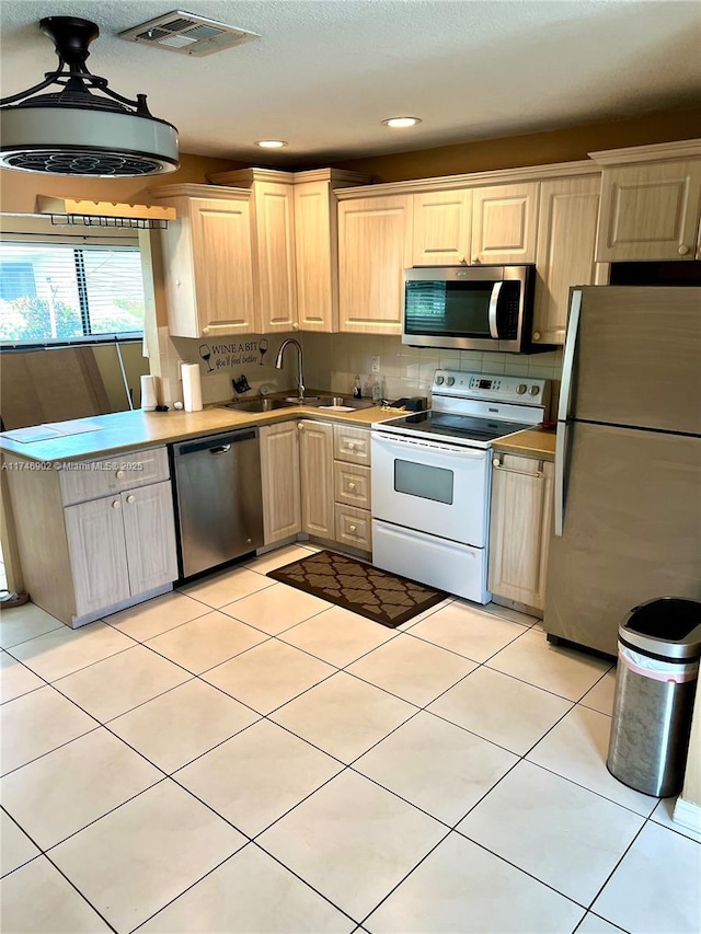 2713 NW 53rd St, Tamarac, FL 33309 - kitchen featuring a sink, visible vents, backsplash, appliances with stainless steel finishes, and light tile patterned floors