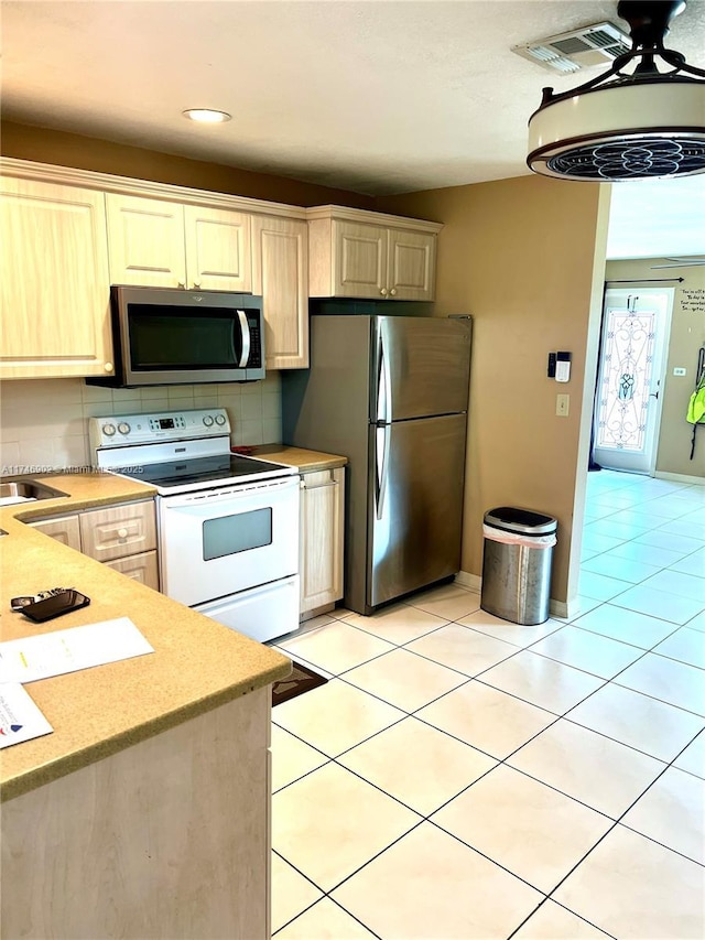 2713 NW 53rd St, Tamarac, FL 33309 - kitchen with appliances with stainless steel finishes, light tile patterned flooring, visible vents, and light countertops