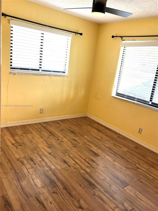 2713 NW 53rd St, Tamarac, FL 33309 - spare room with wood finished floors, a wealth of natural light, a ceiling fan, and baseboards