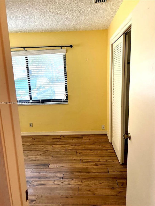 2713 NW 53rd St, Tamarac, FL 33309 - unfurnished bedroom with a textured ceiling, baseboards, visible vents, a closet, and hardwood / wood-style floors