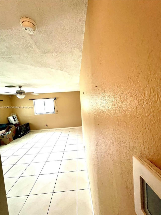 2713 NW 53rd St, Tamarac, FL 33309 - interior space with light tile patterned flooring, a textured wall, a textured ceiling, and a ceiling fan