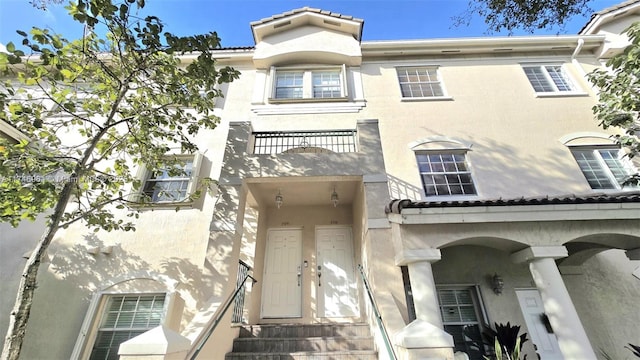 view of property featuring stucco siding and a balcony