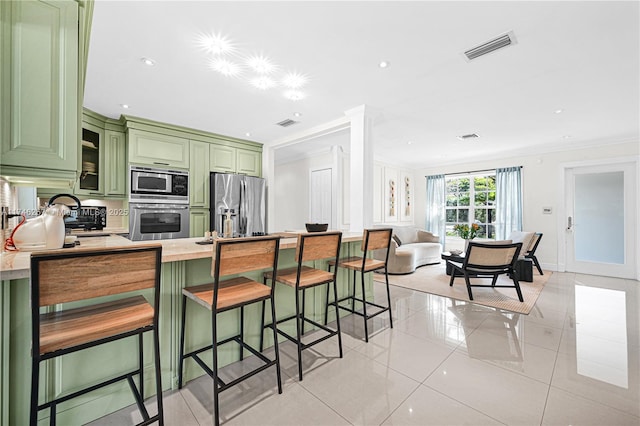 kitchen with crown molding, appliances with stainless steel finishes, green cabinets, and light countertops