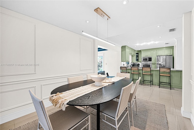 dining room featuring light tile patterned floors, recessed lighting, visible vents, and a decorative wall