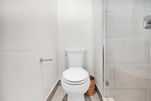 bathroom with tile patterned floors, toilet, and baseboards