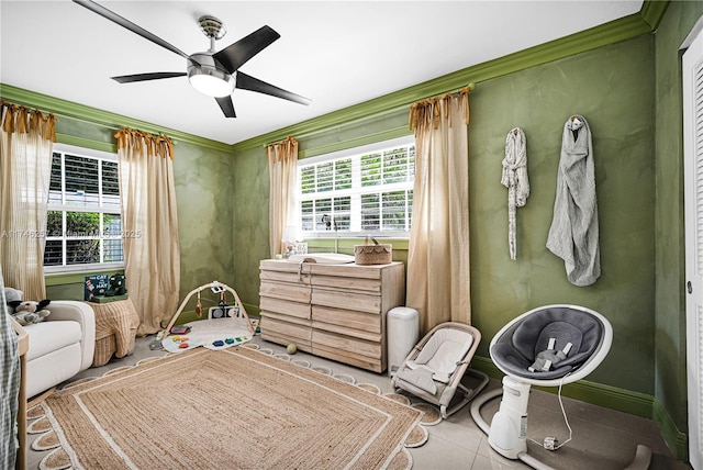 bedroom featuring light tile patterned floors, ornamental molding, a ceiling fan, and baseboards