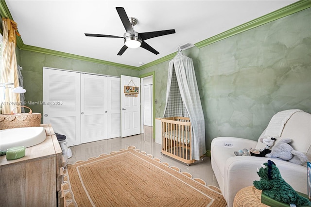 bedroom featuring a sink, a closet, a ceiling fan, and crown molding