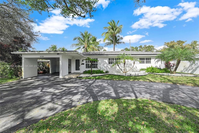 ranch-style house with driveway, a front lawn, and stucco siding