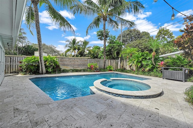 view of pool featuring a patio, a fenced backyard, and a pool with connected hot tub