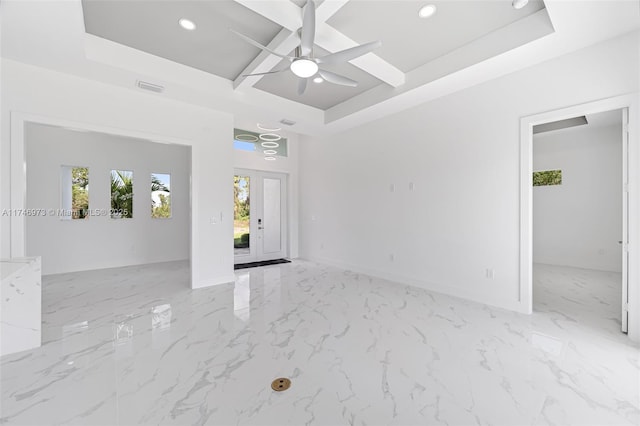 interior space featuring ceiling fan, a tray ceiling, and a high ceiling