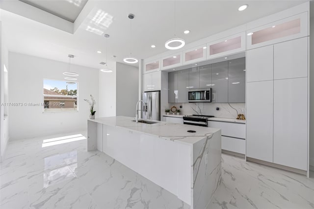 kitchen with a spacious island, sink, tasteful backsplash, hanging light fixtures, and stainless steel appliances