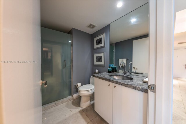 bathroom featuring toilet, tile patterned flooring, vanity, and a shower with door