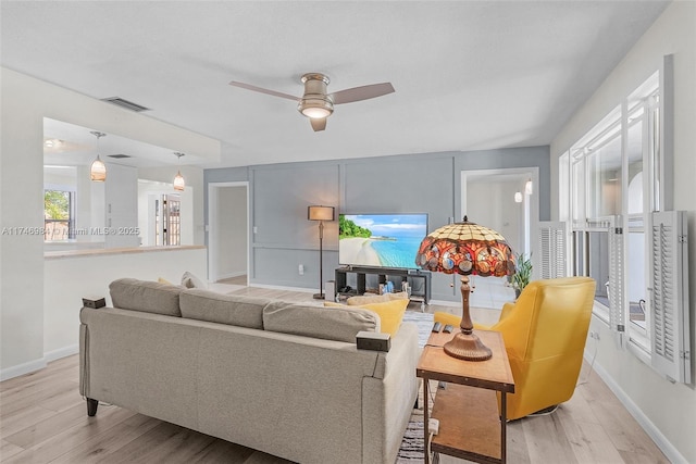 living room with ceiling fan and light hardwood / wood-style flooring