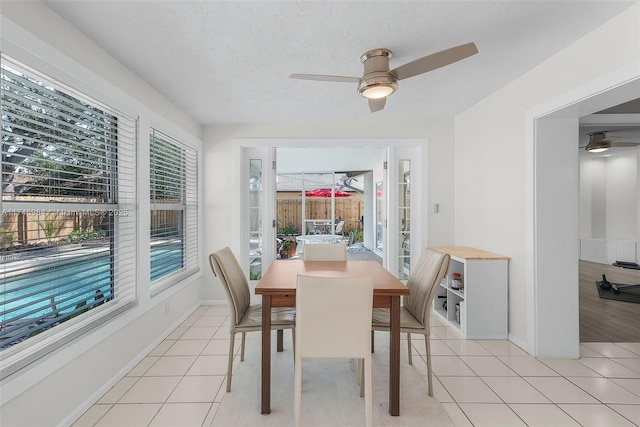 dining space with a textured ceiling, ceiling fan, and light tile patterned floors