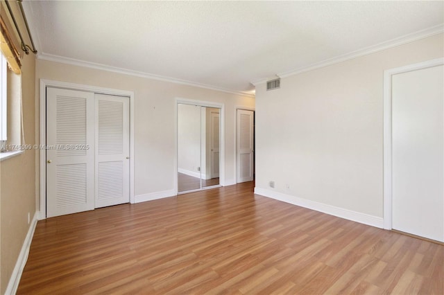 301 NE 14th Ave Unit 201, Hallandale Beach, FL 33009 - unfurnished bedroom featuring two closets, light wood-type flooring, ornamental molding, and baseboards