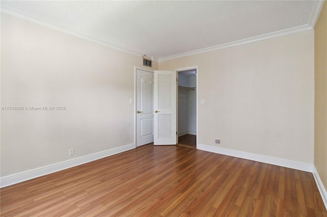 301 NE 14th Ave Unit 201, Hallandale Beach, FL 33009 - unfurnished bedroom with wood finished floors, baseboards, crown molding, a textured ceiling, and a closet