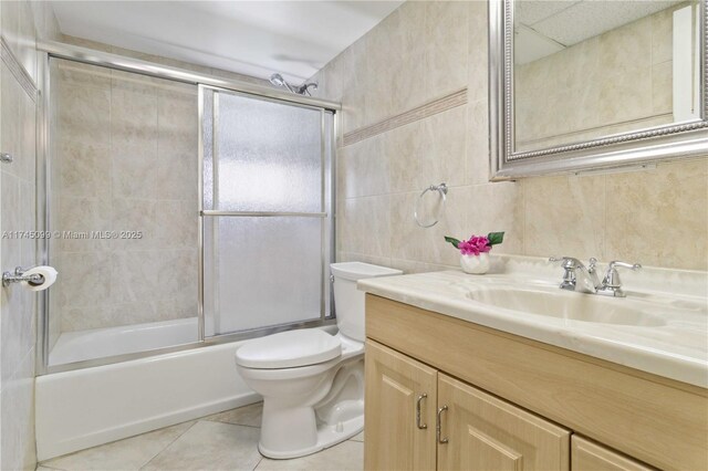 301 NE 14th Ave Unit 201, Hallandale Beach, FL 33009 - bathroom with vanity, tile walls, tile patterned flooring, toilet, and enclosed tub / shower combo