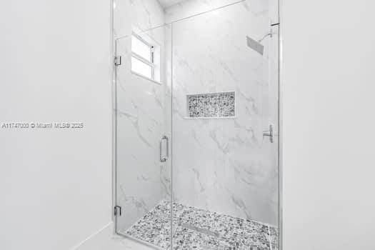 bathroom featuring a shower with door