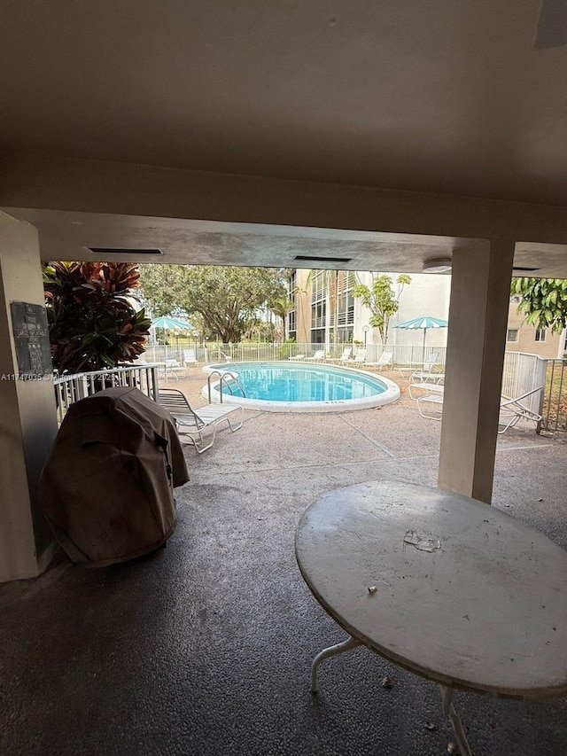 view of swimming pool featuring area for grilling and a patio area