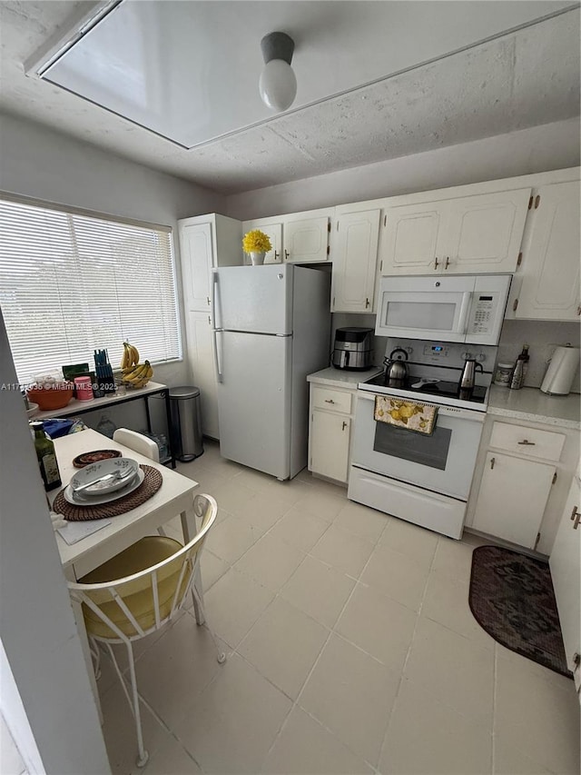 kitchen featuring white cabinetry and white appliances