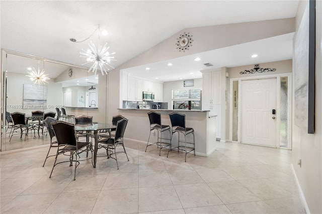 dining area featuring light tile patterned flooring, a notable chandelier, visible vents, baseboards, and vaulted ceiling