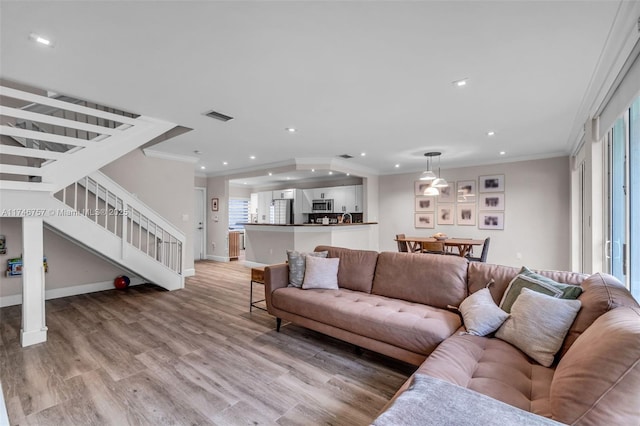 living room featuring light hardwood / wood-style floors and ornamental molding