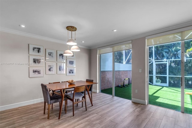 dining room featuring ornamental molding, a wall of windows, and light hardwood / wood-style flooring