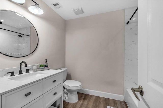 bathroom with toilet, vanity, and wood-type flooring