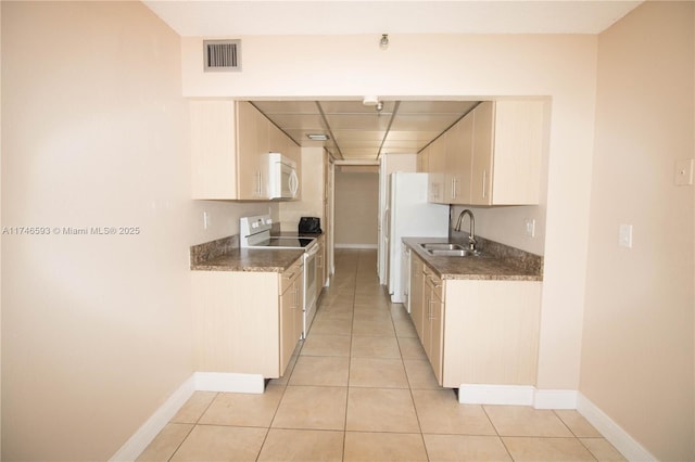 kitchen with sink, white appliances, cream cabinets, and light tile patterned floors