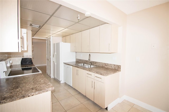 kitchen with sink, white appliances, a paneled ceiling, and light tile patterned floors