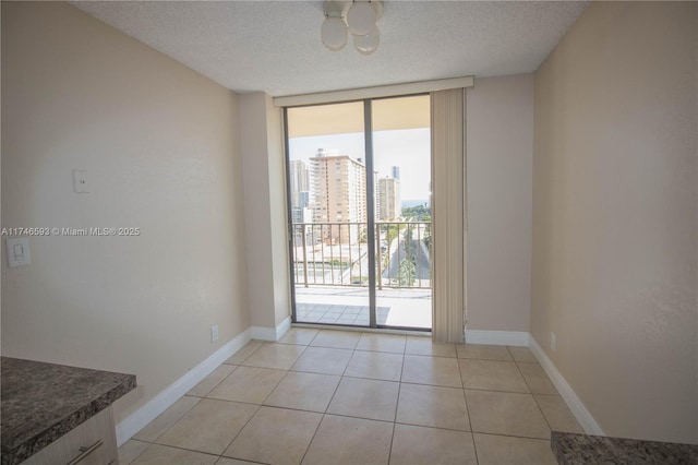 entryway featuring light tile patterned floors, floor to ceiling windows, and a textured ceiling